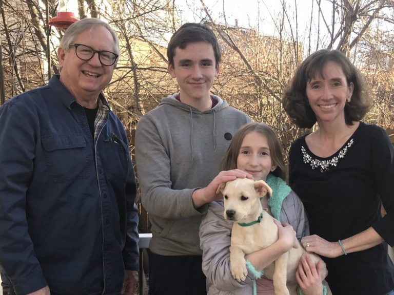 Erin Hottenstein standing with her husband, son, daughter, and new puppy.