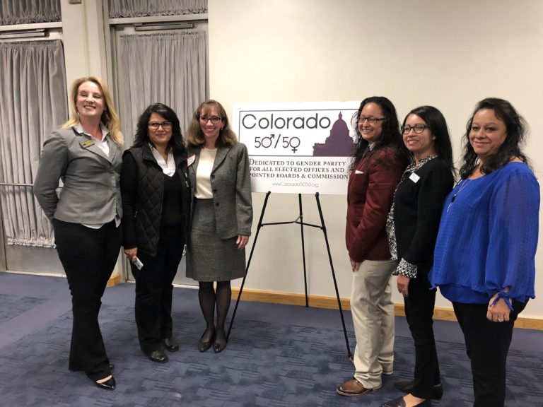 Six women with a Colorado 50-50 sign