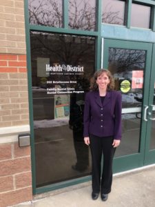 Erin Hottenstein standing at entrance of Health District dental building