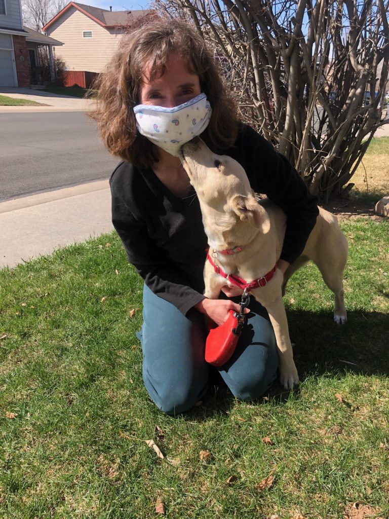 Woman wearing cloth mask and a puppy