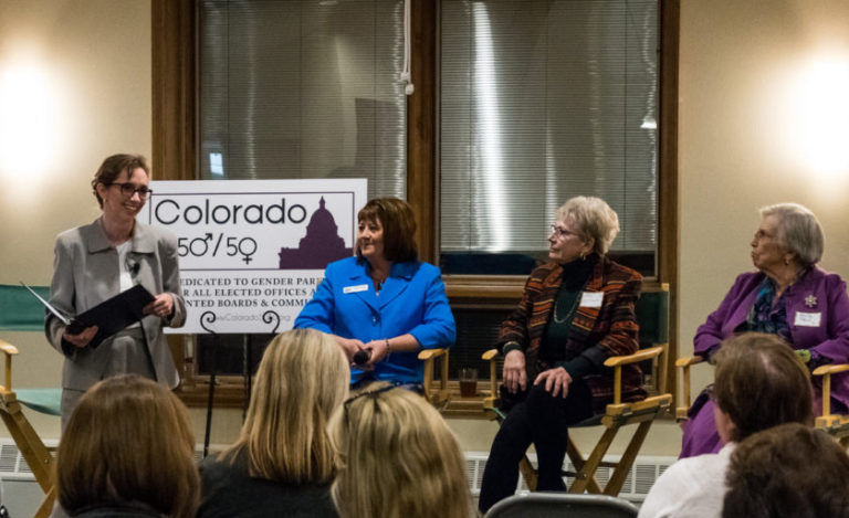 Four women speakers facing an audience